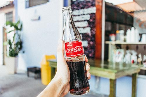 Звідси знамениті як би рукописні плавні лінії в логотипі Coca-Cola